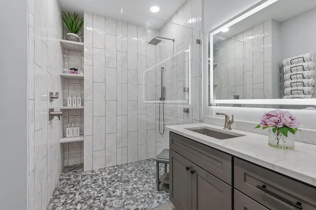 a bathroom with a shower sink and mirror