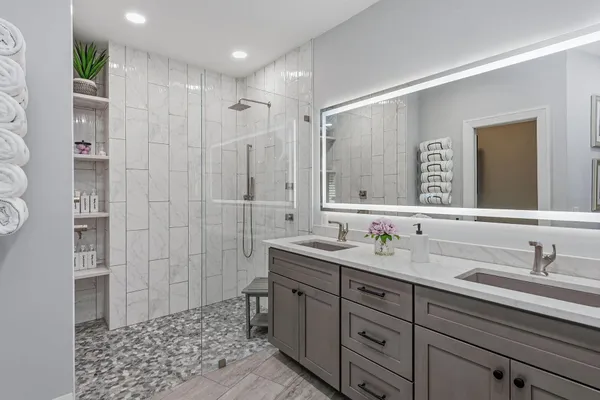 a bathroom with a double vanity sink mirror and shower