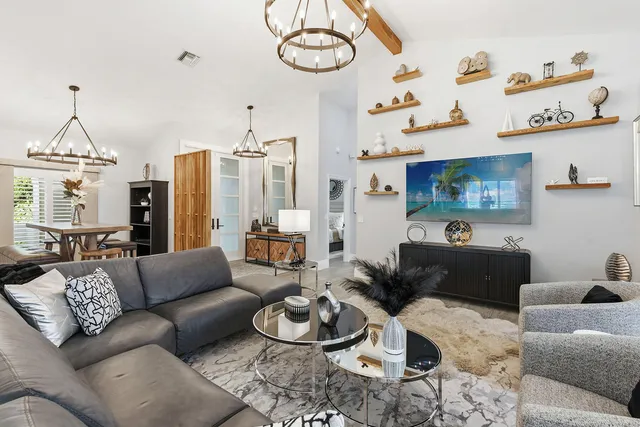 a living room with furniture a clock and a chandelier