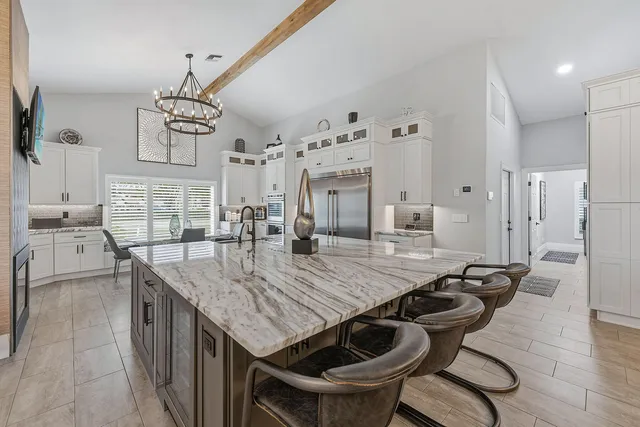a kitchen with granite countertop a table chairs and wooden floor