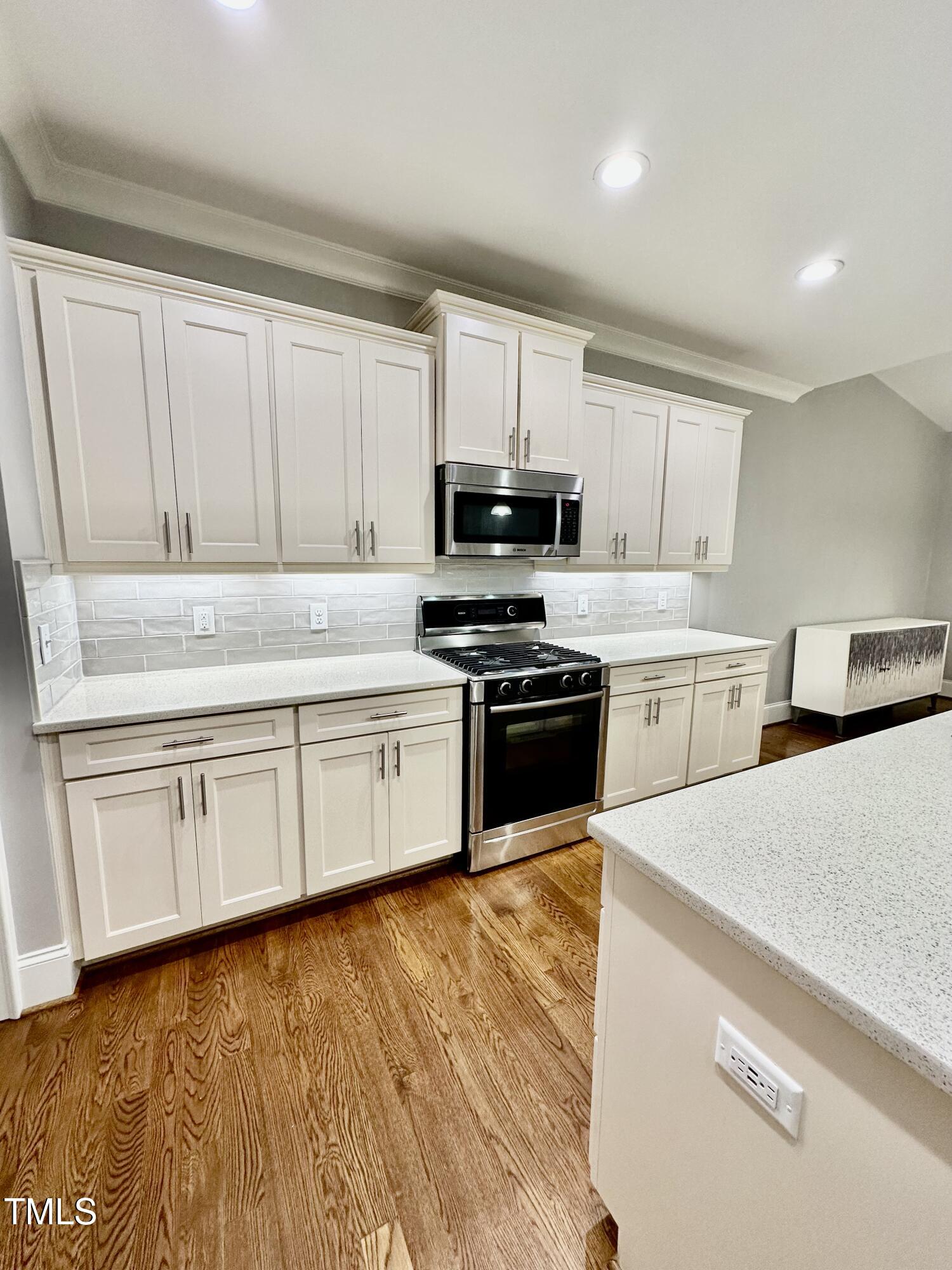129 Cofield Circle Durham, NC 27707 - Photo 11 of 37 a kitchen with granite countertop white cabinets and black appliances