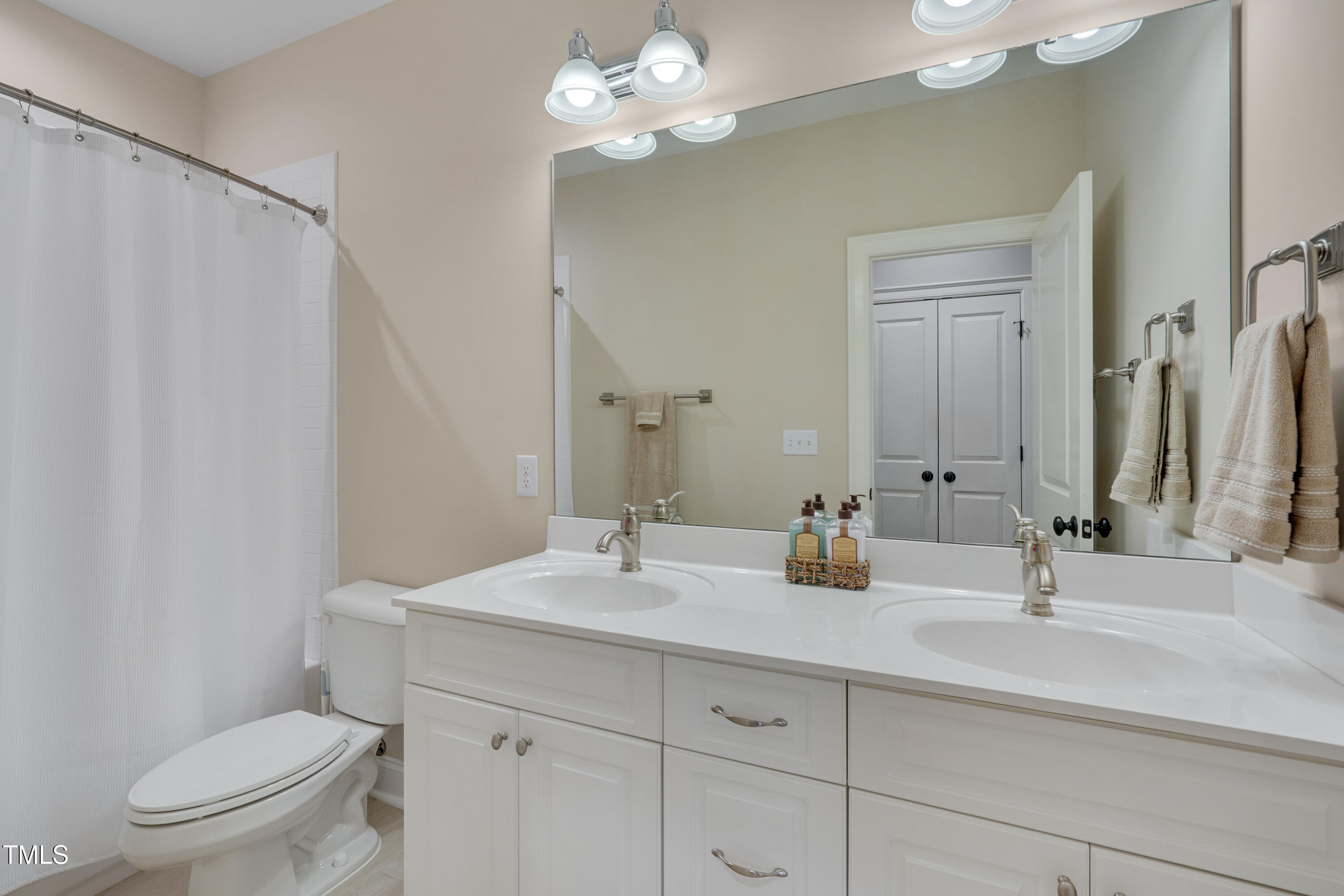 129 Cofield Circle Durham, NC 27707 - Photo 26 of 37 a bathroom with a sink a toilet a large mirror and shower curtain