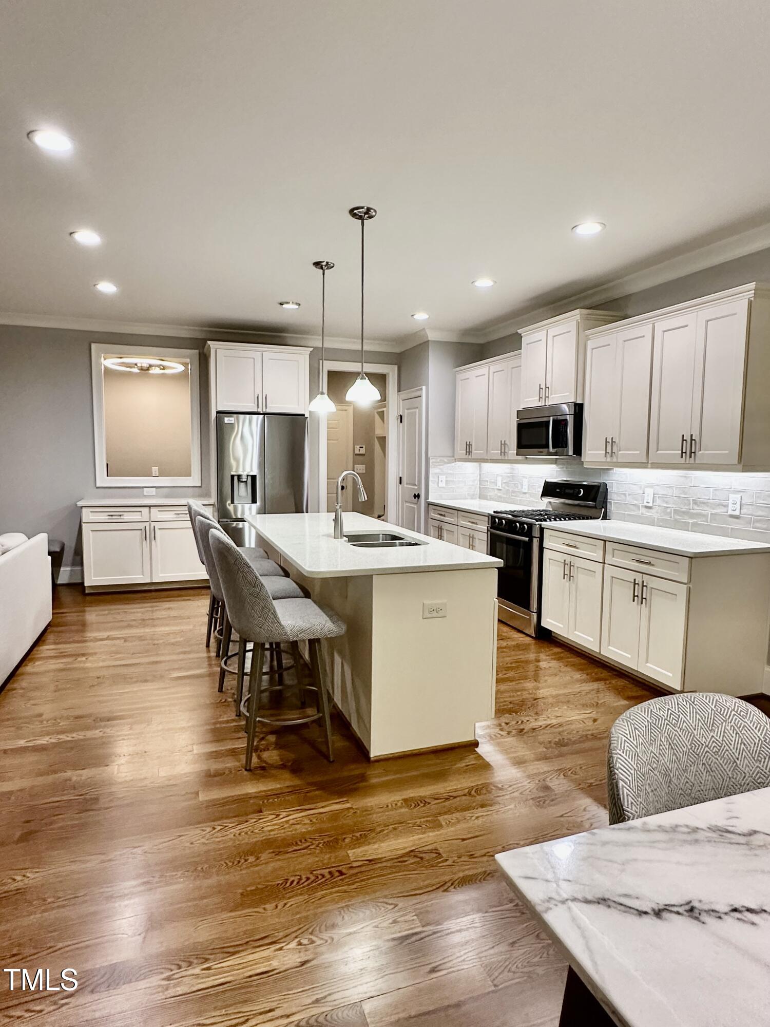129 Cofield Circle Durham, NC 27707 - Photo 9 of 37 a large kitchen with kitchen island a stove a sink a dining table and chairs
