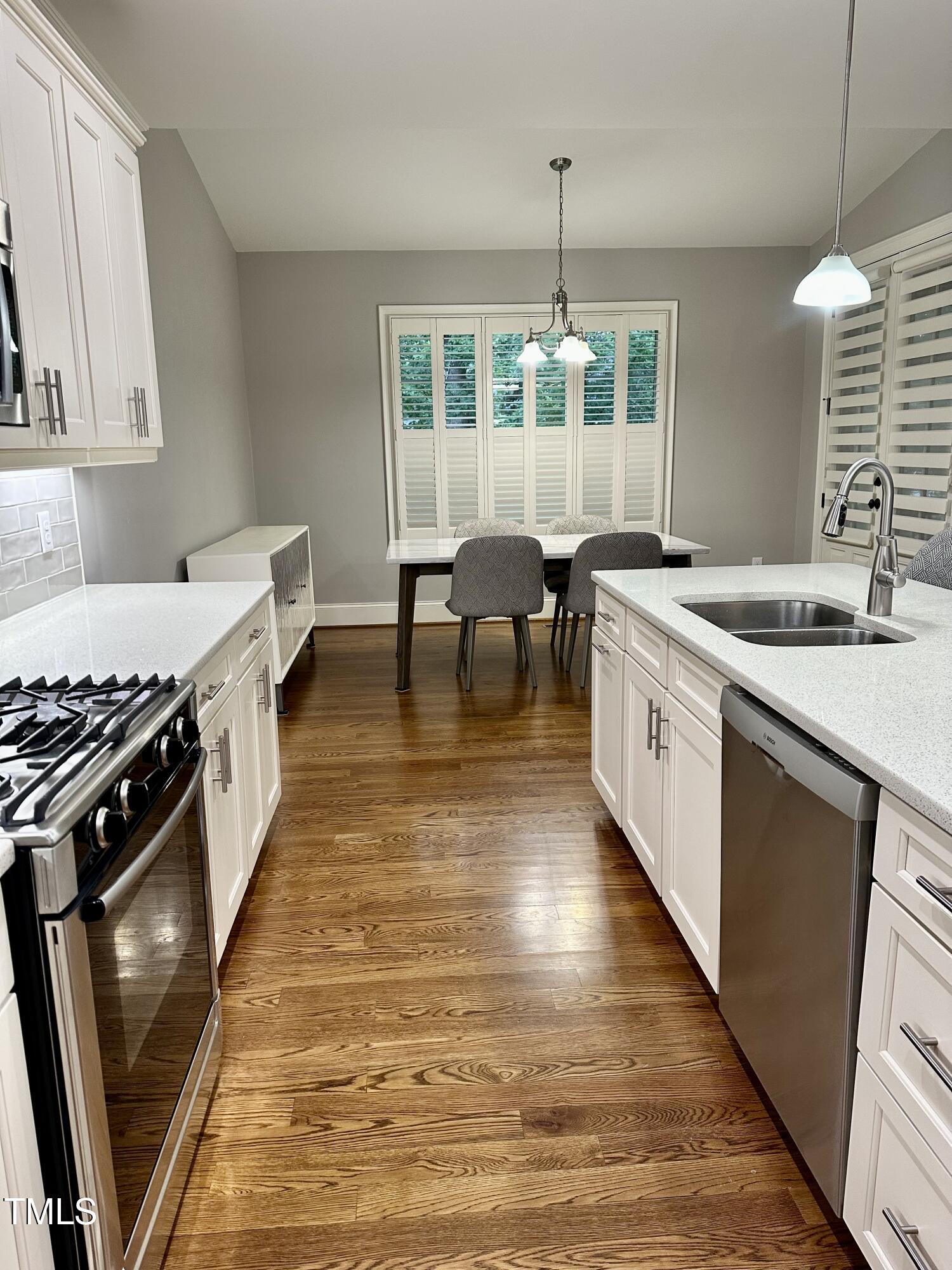 129 Cofield Circle Durham, NC 27707 - Photo 10 of 37 a kitchen with kitchen island a counter space a sink a stove and wooden floor