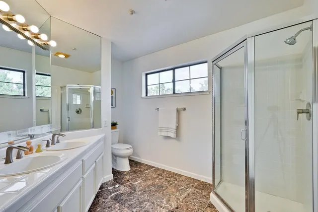 a bathroom with a double vanity sink toilet and shower