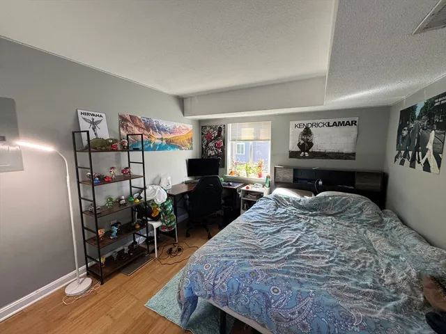 a bedroom with a bed and wooden floor