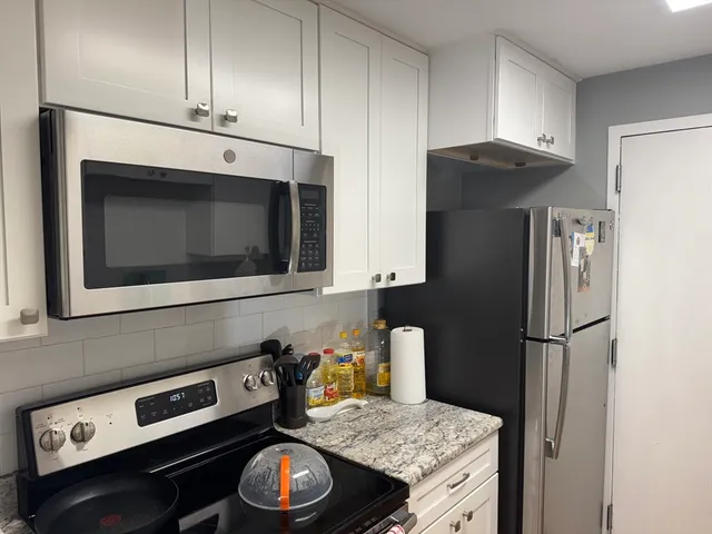 a kitchen with stainless steel appliances granite countertop a stove a microwave and a refrigerator