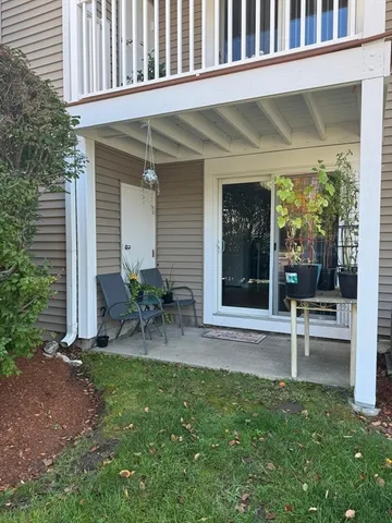 a view of a chair and table in back yard of the house