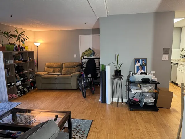 a living room with furniture a flat screen tv and gym equipment