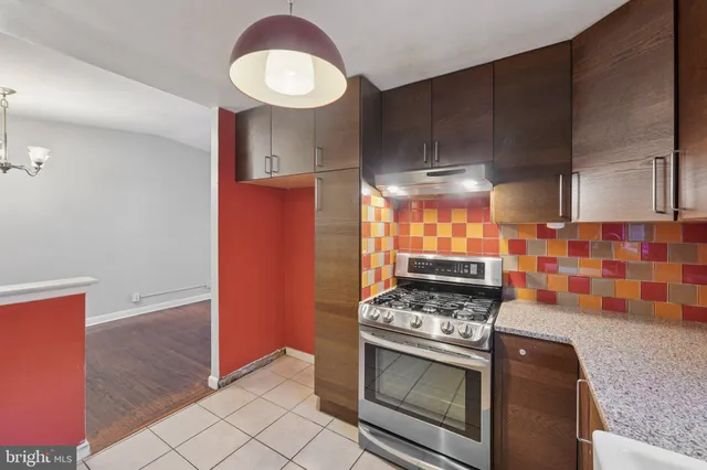 a kitchen with granite countertop stainless steel appliances a stove a sink and a microwave