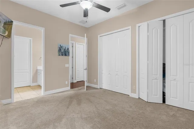 an empty room with chandelier fan