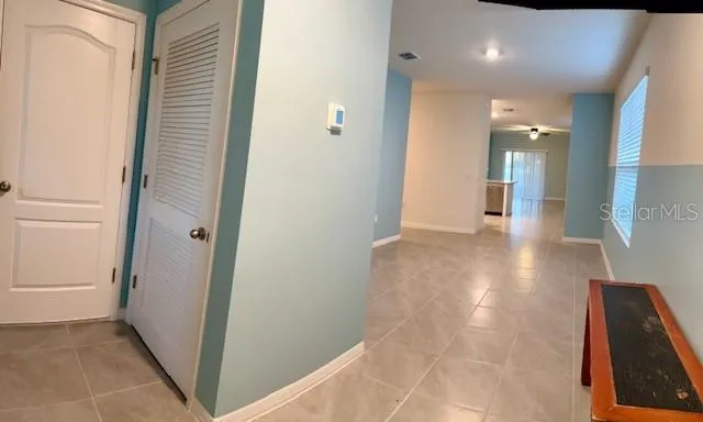 a view of a hallway with entryway and wooden floor