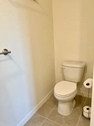 a white toilet sitting next to a white wall