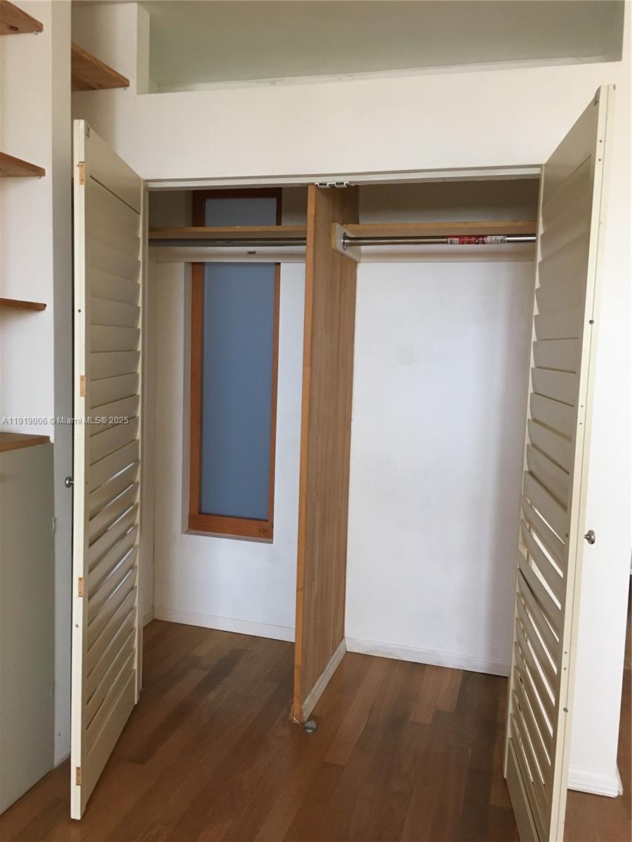 16400 Northeast 17th Avenue, Unit 3042 North Miami Beach, FL 33162 - Photo 11 of 17 an empty room with wooden floor and windows