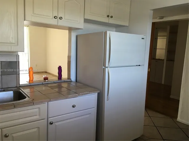 a kitchen with a refrigerator and a sink