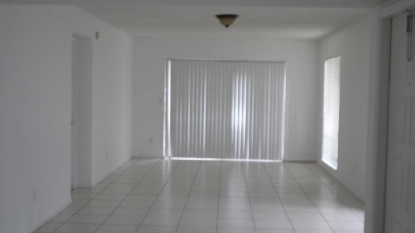 8294 Boca Rio Drive Boca Raton, FL 33433 - Photo 4 of 18 an empty room with wooden floor and windows