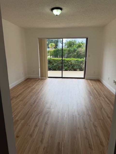 8294 Boca Rio Drive Boca Raton, FL 33433 - Photo 6 of 18 a view of an empty room with wooden floor and a window