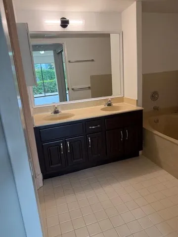 a bathroom with a tub sink and mirror
