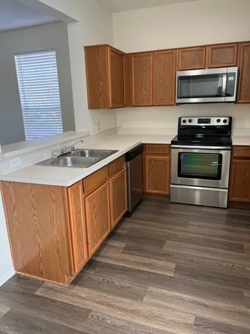 a kitchen with stainless steel appliances a stove a microwave and sink