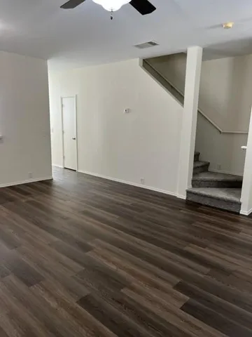 a view of an empty room with wooden floor