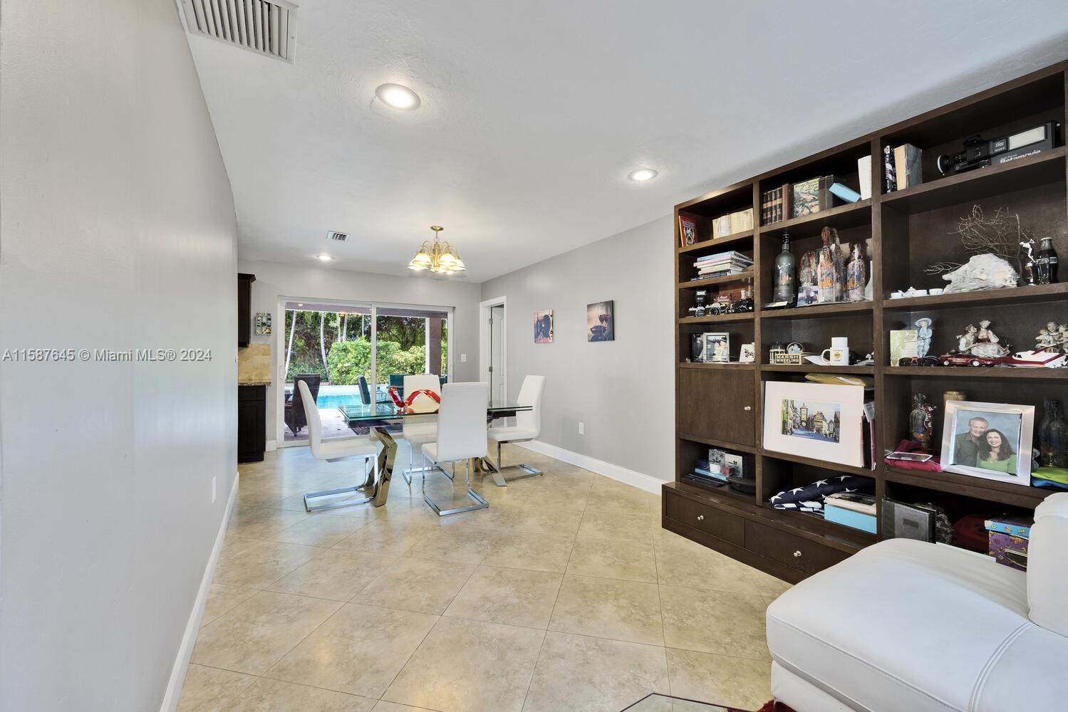 18565 Southwest 295th Terrace Homestead, FL 33030 - Photo 13 of 42 a living room with furniture a rug and a book shelf