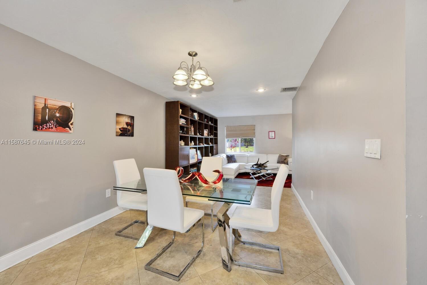 18565 Southwest 295th Terrace Homestead, FL 33030 - Photo 16 of 42 a view of a dining room with furniture and chandelier
