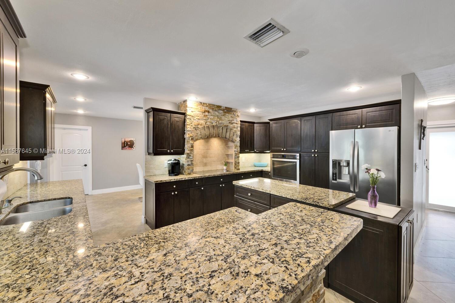 18565 Southwest 295th Terrace Homestead, FL 33030 - Photo 21 of 42 a large kitchen with kitchen island a sink stainless steel appliances and cabinets