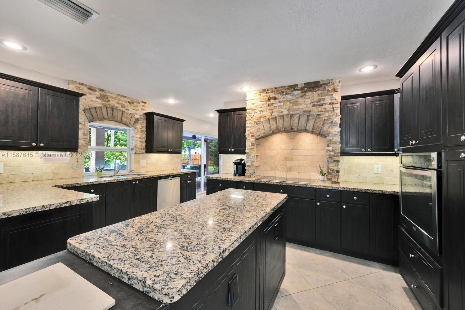 18565 Southwest 295th Terrace Homestead, FL 33030 - Photo 22 of 42 a kitchen with stainless steel appliances granite countertop a sink counter space and cabinets