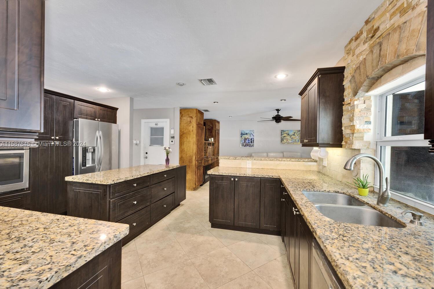 18565 Southwest 295th Terrace Homestead, FL 33030 - Photo 24 of 42 a kitchen with granite countertop a sink stove and refrigerator