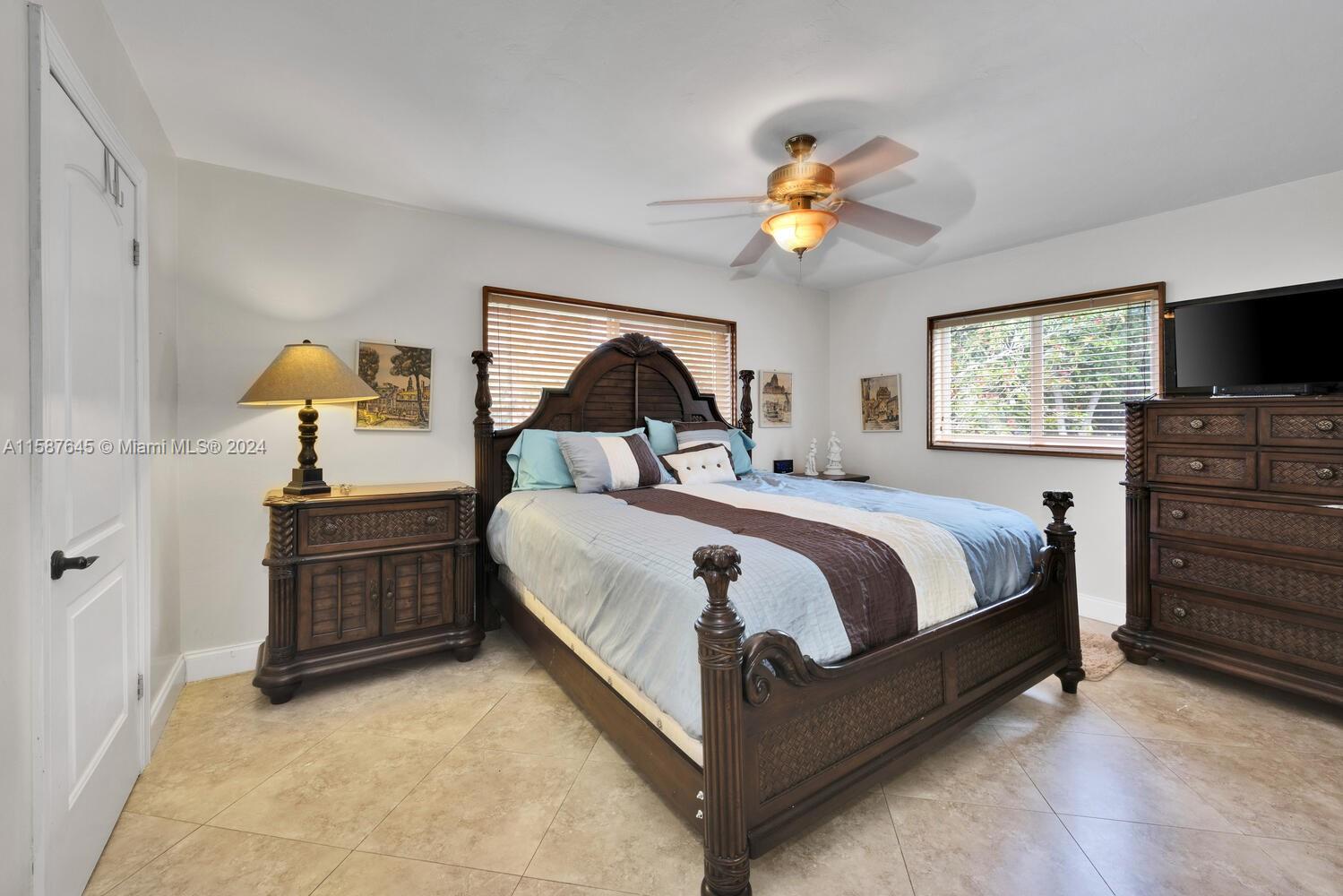 18565 Southwest 295th Terrace Homestead, FL 33030 - Photo 29 of 42 a bedroom with a bed and a chandelier