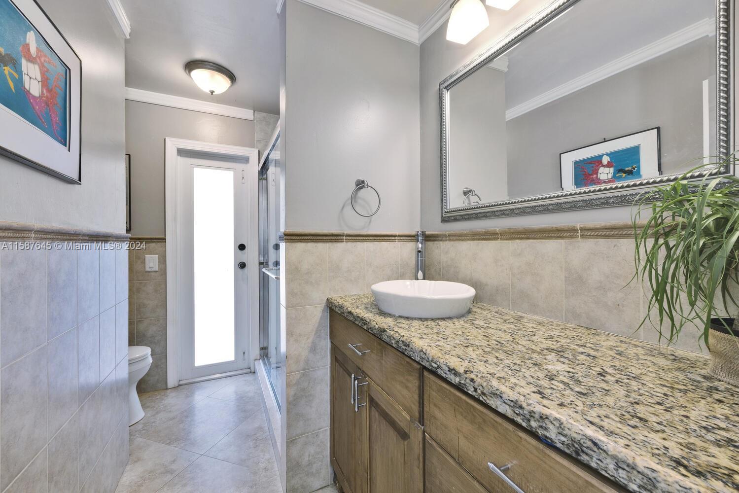 18565 Southwest 295th Terrace Homestead, FL 33030 - Photo 32 of 42 a bathroom with a granite countertop sink and a mirror