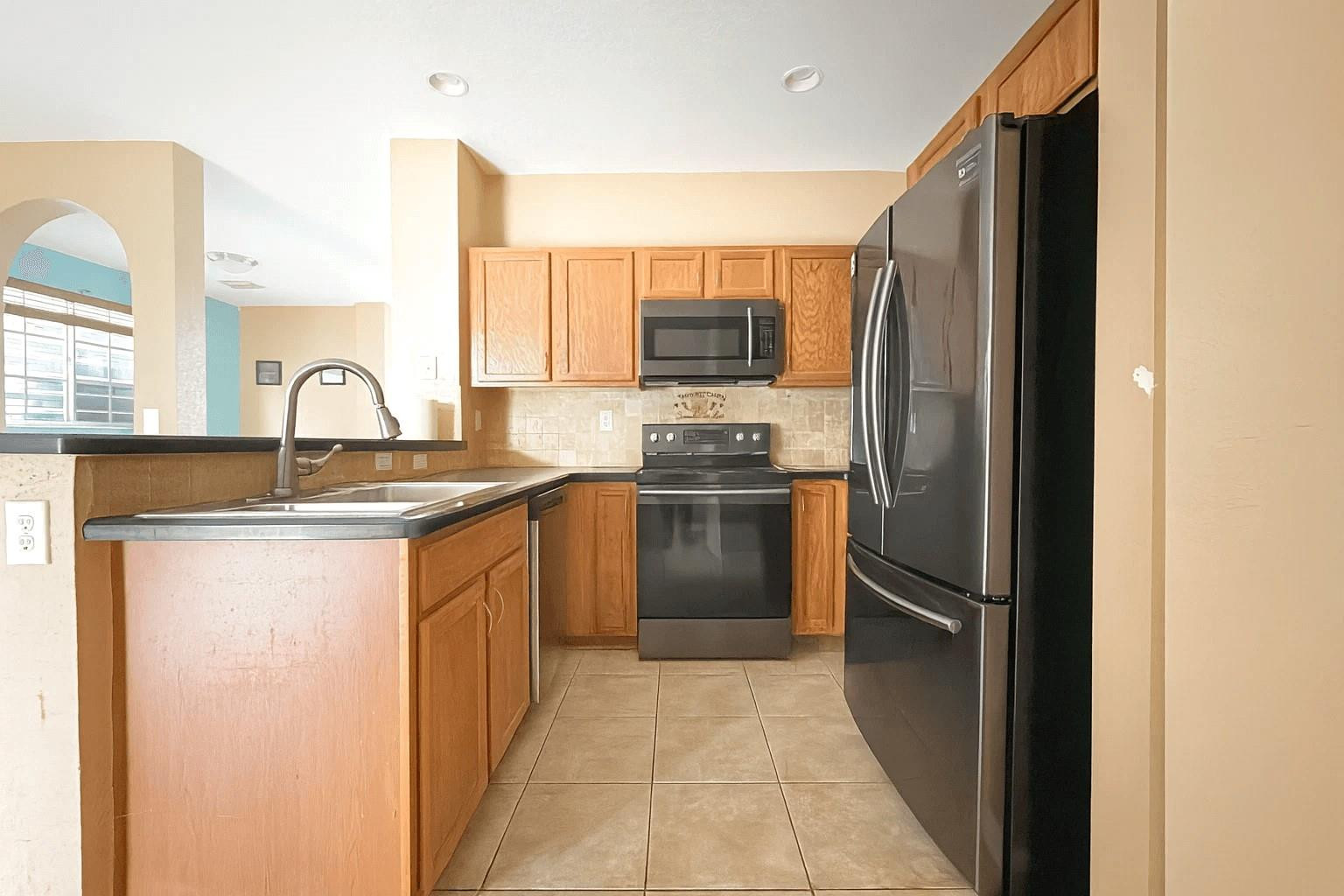 14218 Southwest 272nd Street, Unit 1 Homestead, FL 33032 - Photo 9 of 24 a kitchen with granite countertop a refrigerator and a sink