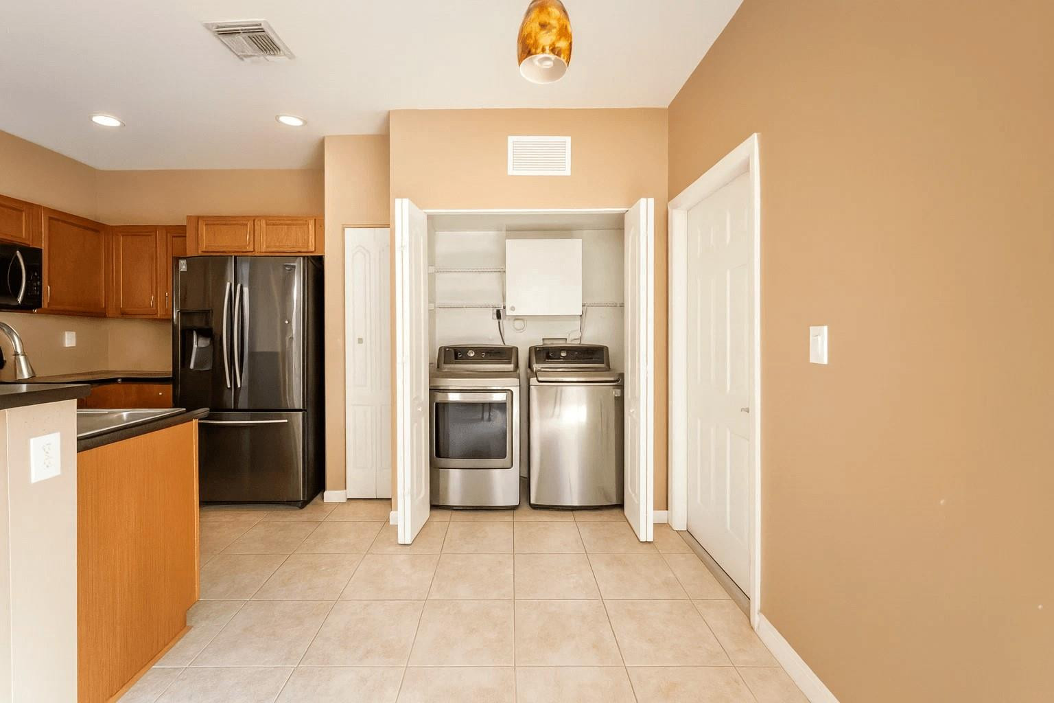 14218 Southwest 272nd Street, Unit 1 Homestead, FL 33032 - Photo 10 of 24 a kitchen with a refrigerator and a stove top oven