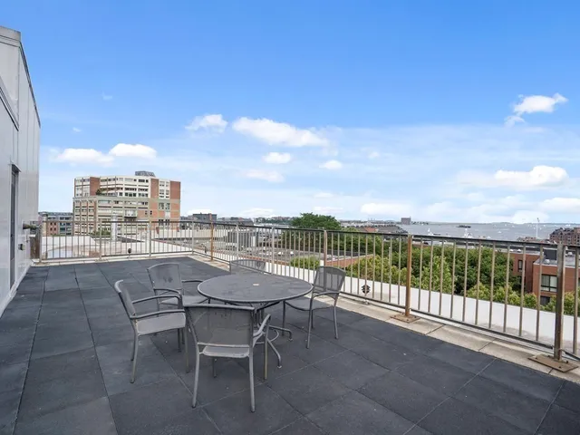 a view of a terrace with furniture and city view