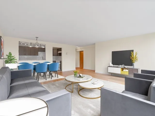 a living room with furniture a flat screen tv and a dining table