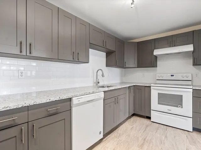 a kitchen with granite countertop cabinets stainless steel appliances and sink