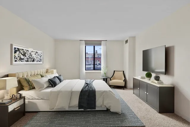 a spacious bedroom with a bed and a flat screen tv