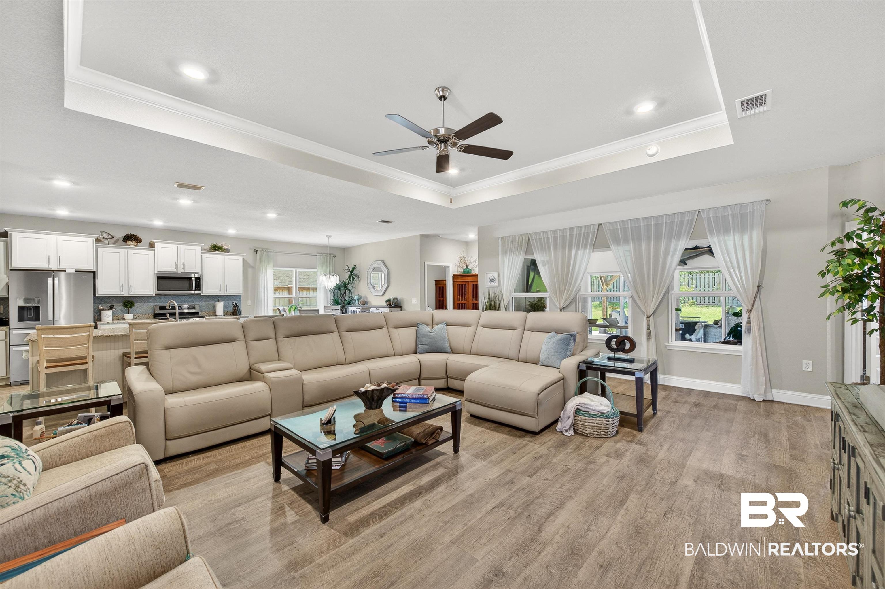 8735 Bronze Lane Foley, AL 36535 - Photo 3 of 58 Open-concept living space featuring wood-finish flooring and a tray ceiling with recessed lighting