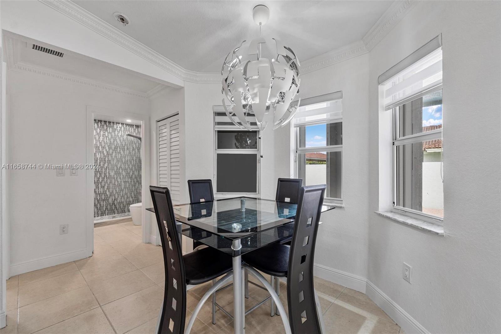 3209 Southwest 142nd Place Miami, FL 33175 - Photo 11 of 42 a view of a dining room with furniture a chandelier and window