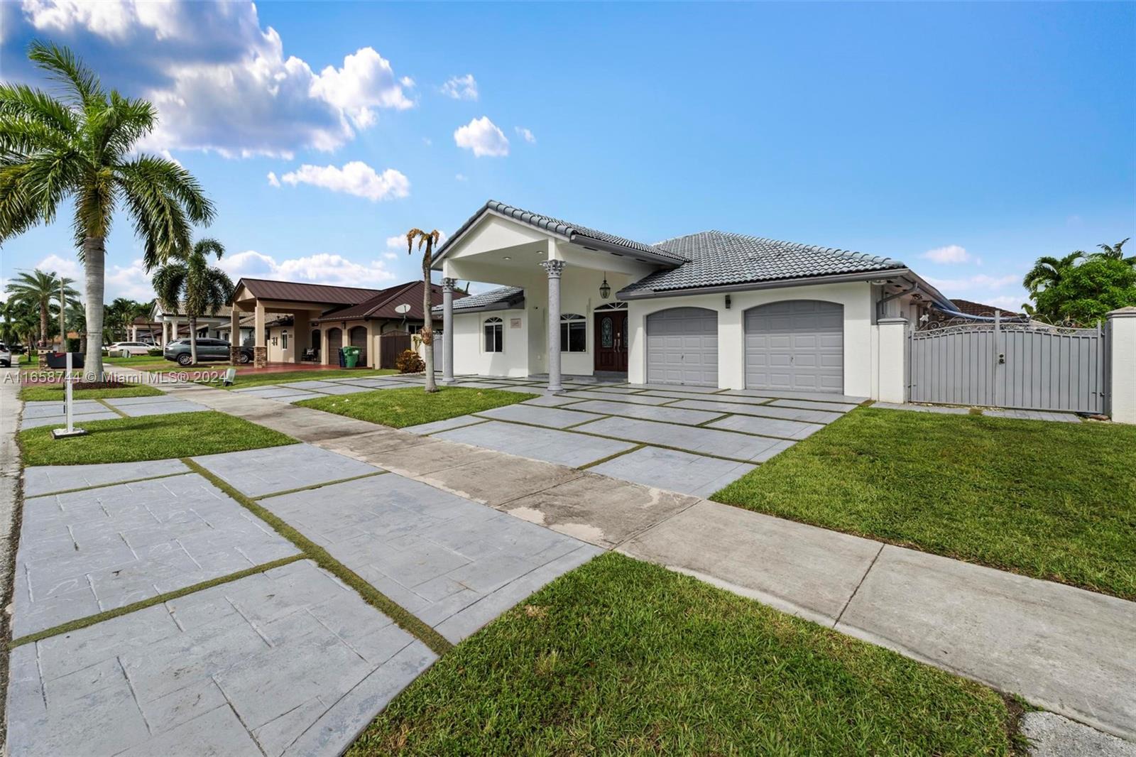 3209 Southwest 142nd Place Miami, FL 33175 - Photo 3 of 42 a front view of a house with a yard and potted plants
