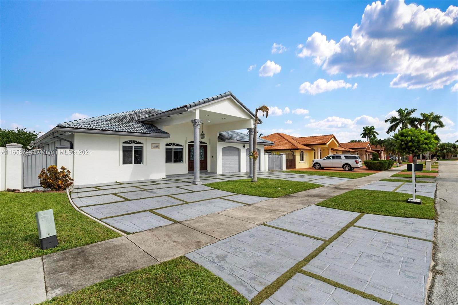 3209 Southwest 142nd Place Miami, FL 33175 - Photo 4 of 42 a front view of a house with a yard and potted plants