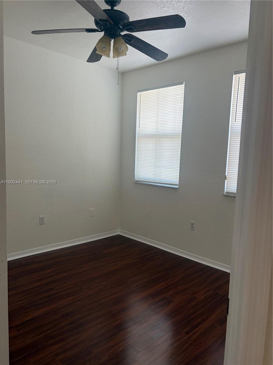 12398 Southwest 125th Terrace Miami, FL 33186 - Photo 30 of 45 an empty room with wooden floor fan and windows