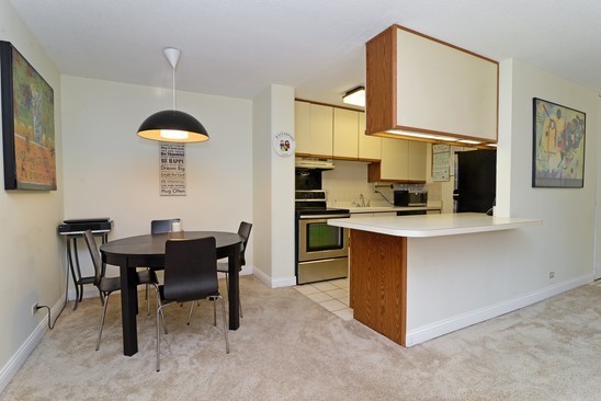 1339 North Dearborn Street, Unit 4H Chicago, IL 60610 - Photo 4 of 13 a kitchen with a table chairs refrigerator and microwave