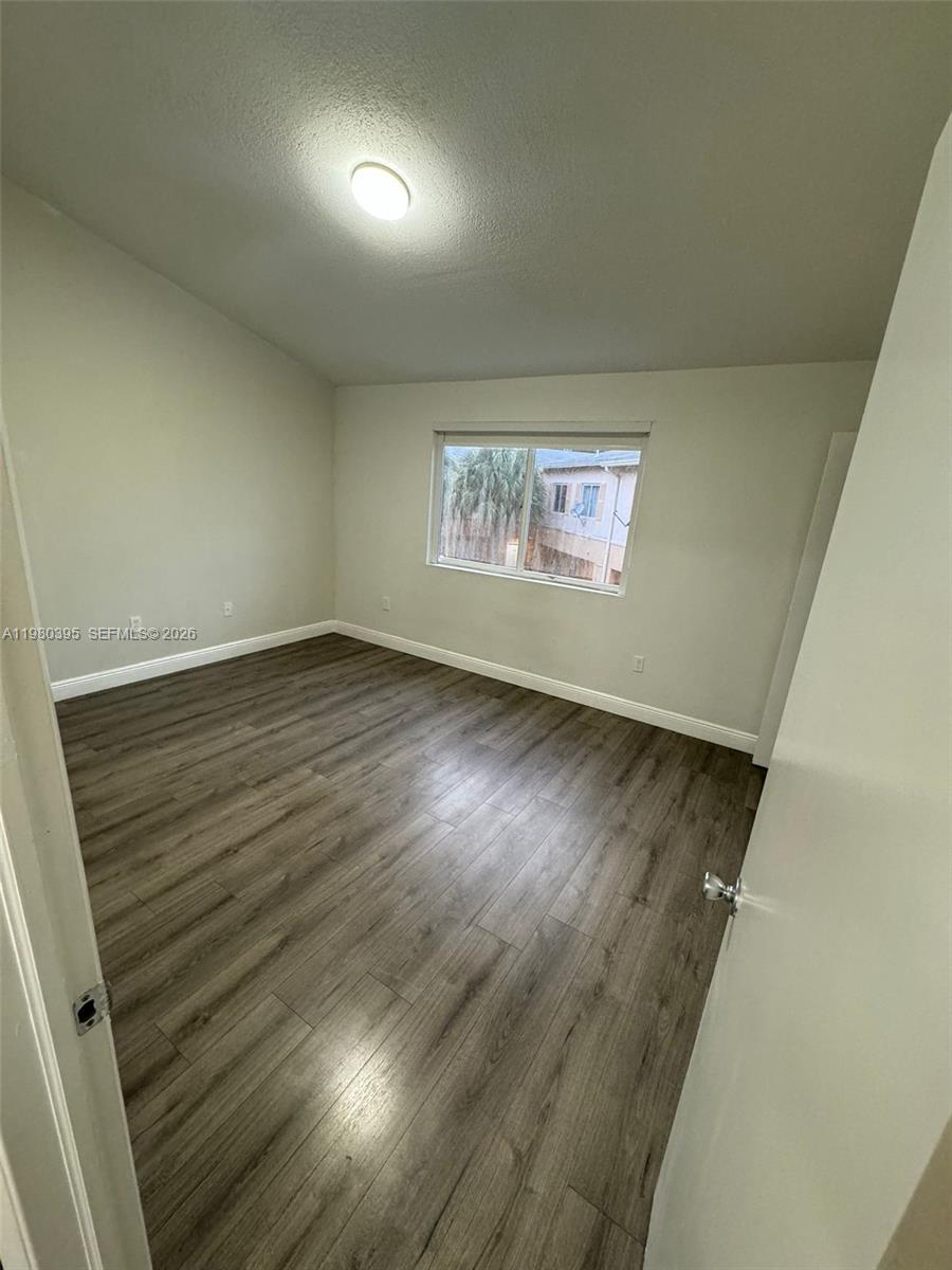 6235 Southwest Kendale Lakes Circle, Unit 237 Miami, FL 33183 - Photo 17 of 24 an empty room with wooden floor and windows