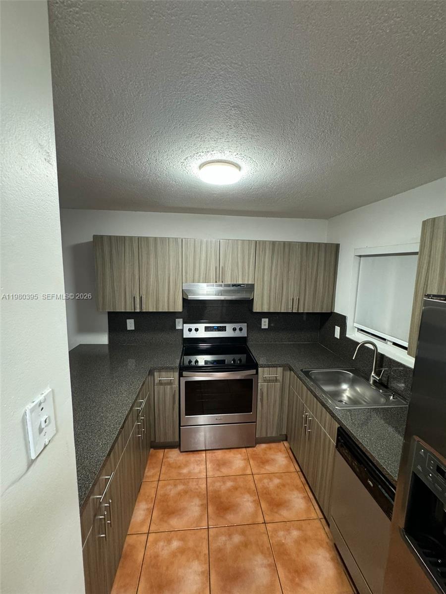 6235 Southwest Kendale Lakes Circle, Unit 237 Miami, FL 33183 - Photo 2 of 24 a kitchen with granite countertop stainless steel appliances a stove sink and cabinets