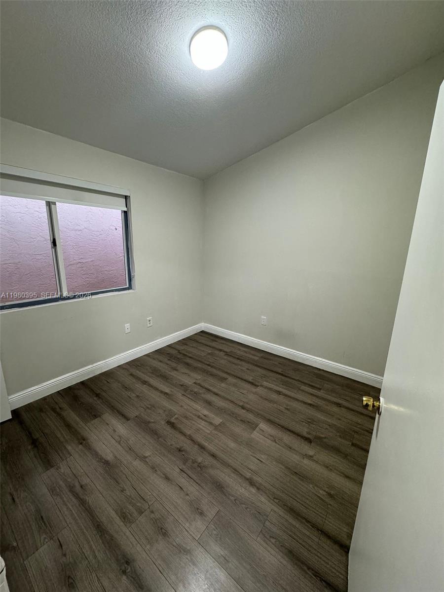 6235 Southwest Kendale Lakes Circle, Unit 237 Miami, FL 33183 - Photo 21 of 24 an empty room with wooden floor and windows