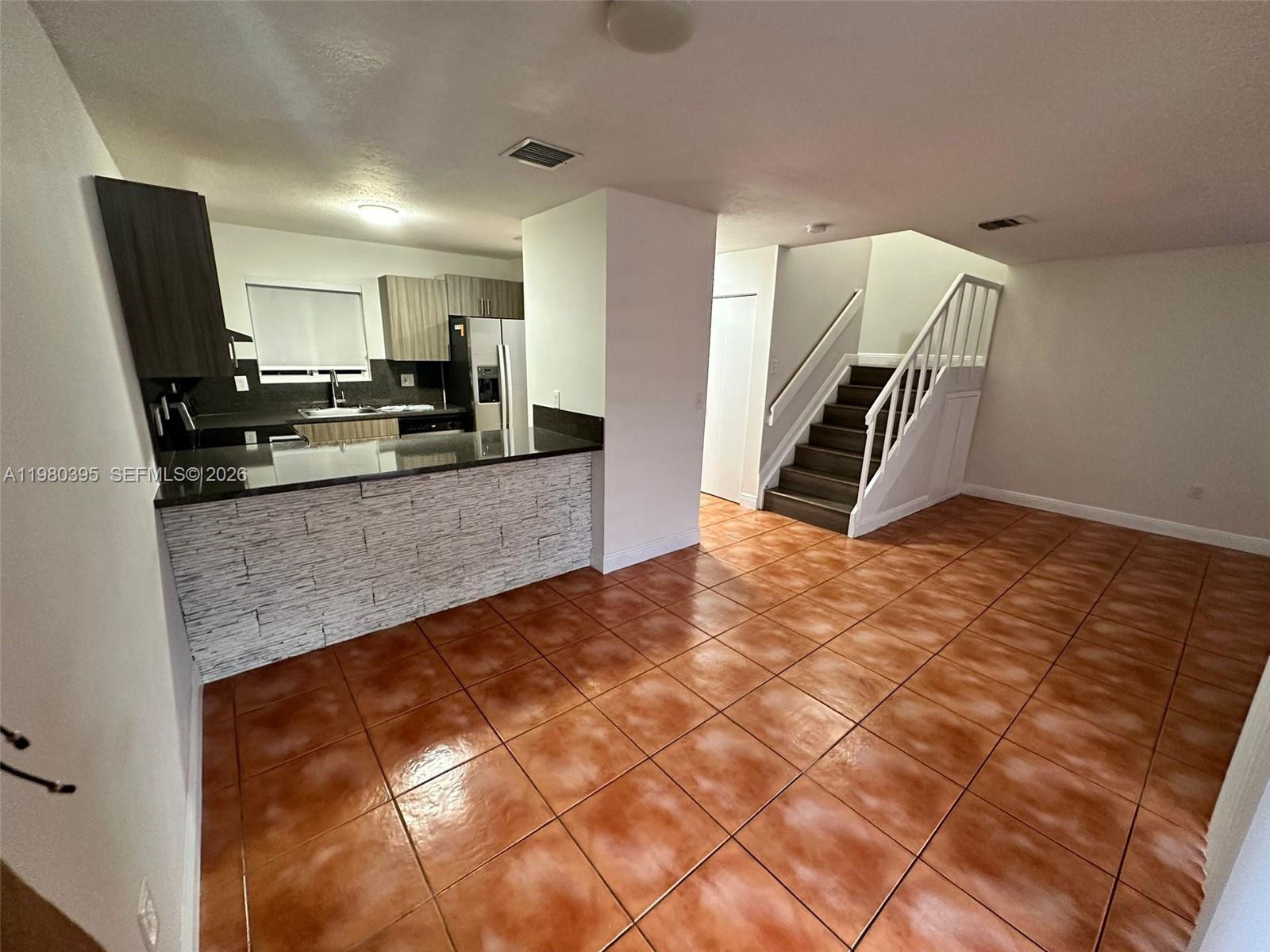 6235 Southwest Kendale Lakes Circle, Unit 237 Miami, FL 33183 - Photo 6 of 24 a kitchen with granite countertop a stove a sink and a refrigerator
