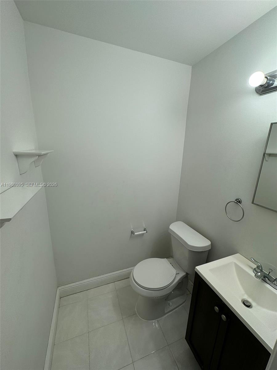 6235 Southwest Kendale Lakes Circle, Unit 237 Miami, FL 33183 - Photo 8 of 24 a white toilet sitting next to a bathroom sink