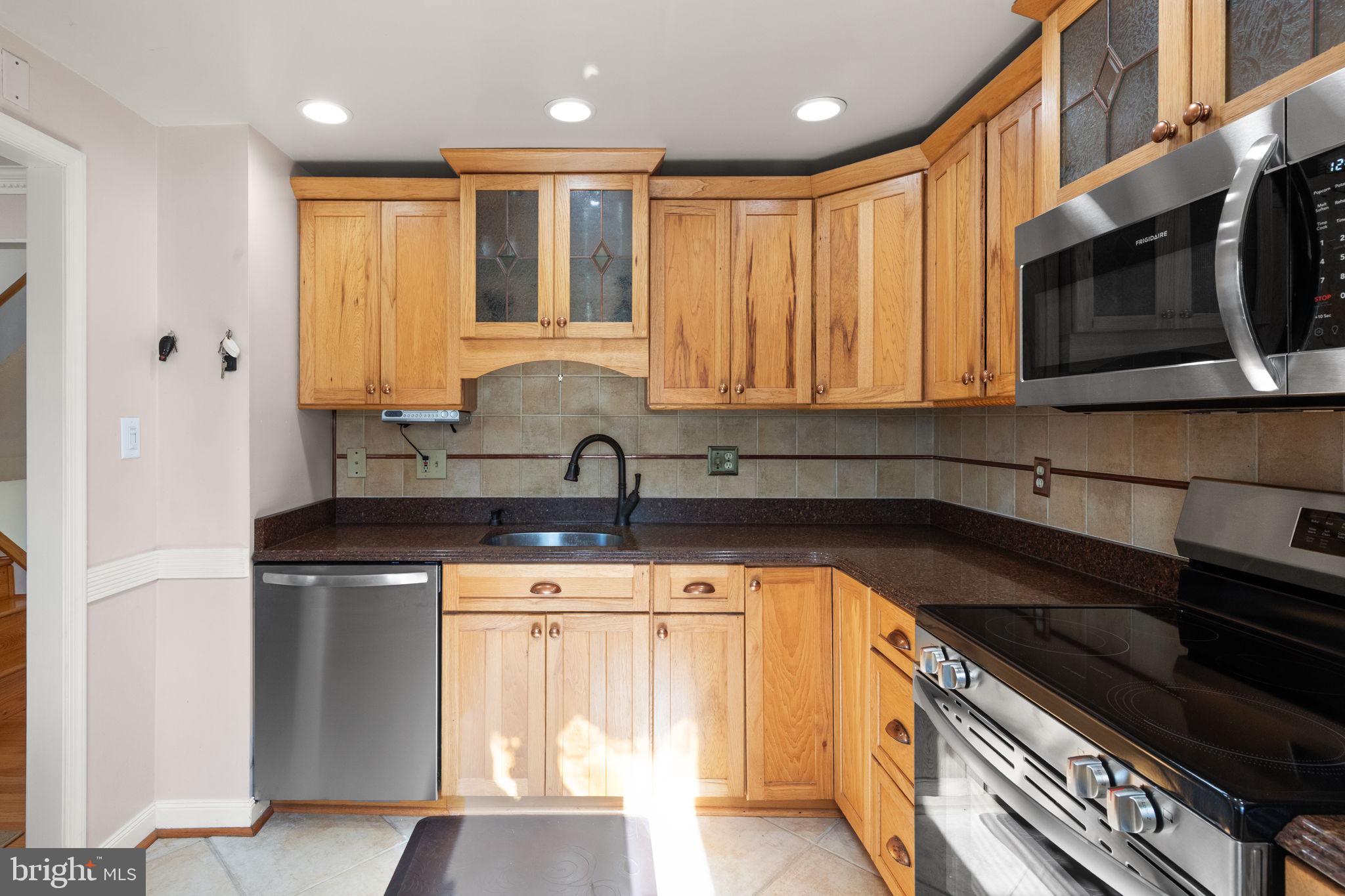4802 Variation Road Nottingham, MD 21236 - Photo 11 of 32 a kitchen with stainless steel appliances granite countertop a sink a stove microwave and cabinets