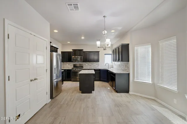 a large kitchen with a large window and stainless steel appliances